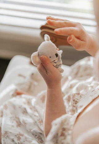 Little girl holding a Rugaroo Koala plush doll with, soft ears, and iconic Australian character design for kids’ play.