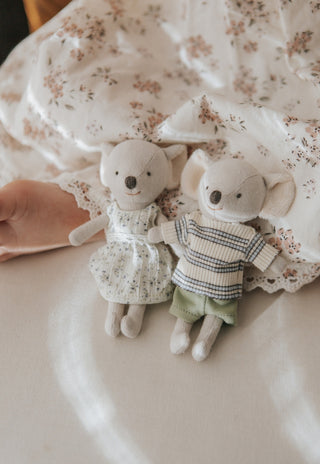 Little girl holding two Rugaroo Koala plush dolls — matching floral dresses, soft ears, and iconic Australian character design for kids’ play.