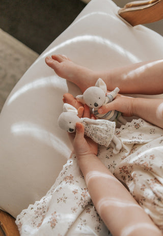 Child playing with a pair of miniature Rugaroo Koala dolls, cuddling the soft linen Aussie toys and creating her own adventure scenes.