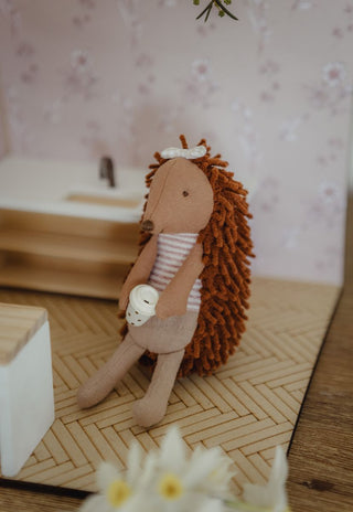 A miniature Rugaroo echidna doll holding a miniature keep cup