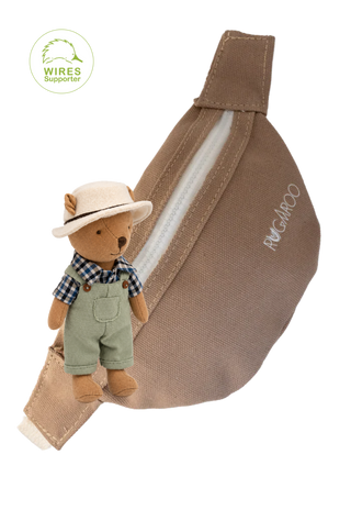 A brown canvas bum bag with a white zipper and embroidered 'RUGAROO' brand name, shown with a small plush farmer wombat doll wearing a hat and overalls attached near the front.