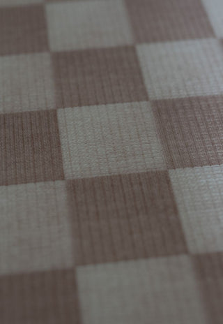 round checkered foam padded baby play mat in latte colour that looks like rug