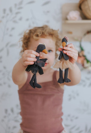 Young girl holding Maali and Wattle Rugaroo black swan miniature plush dolls - premium Australian heirloom collectible toys for children