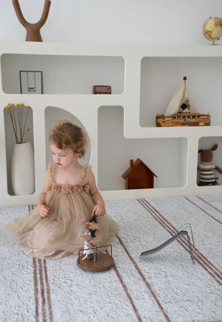 Child playing on Rugabub Cala neutral striped padded baby play mat.