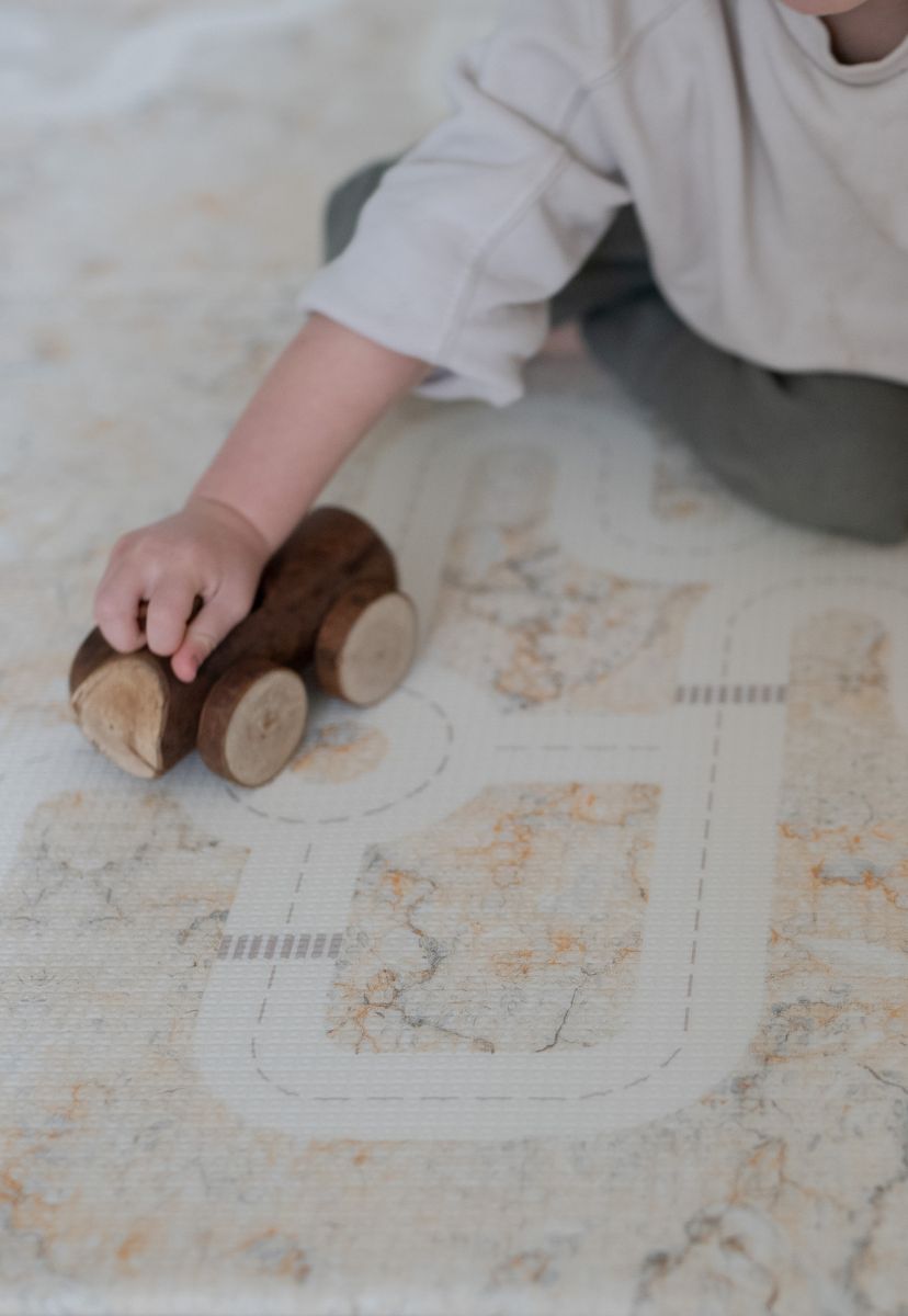 neutral play mat with car tracks and train tracks