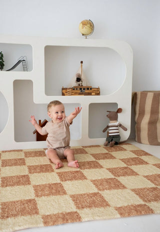 Happy baby sitting on Rugabub Phoenix checkered non toxic foam baby play mat.