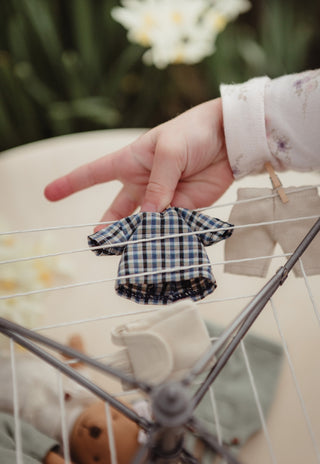 Girl hanging a tiny plaid shirt on a miniature Australian clothesline toy