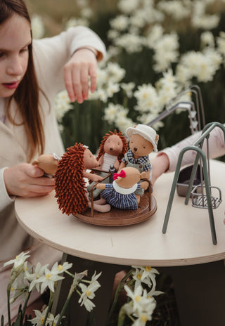 Girl playing with Rugaroo echidna and wombat dolls on a miniature playground set