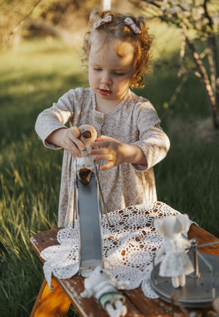 Child playing with miniature dolls  on slide outdoors on a sunny day