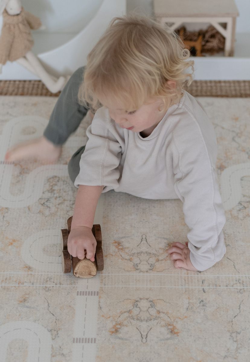 neutral play mat with car tracks and train tracks