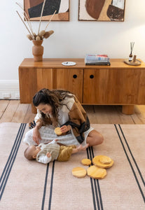 Foam padded baby play mat with black stripes that looks like a rug