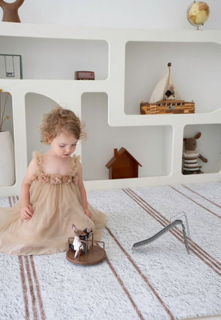 Luxury neutral striped Rugabub Cala foam baby play mat styled in nursery.
