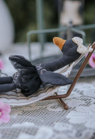 Maali the black swan Rugaroo Australian animal doll reclining on a miniature striped hammock outdoors