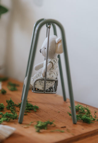 miniature koala doll sitting in a miniature metal swing toy for kids