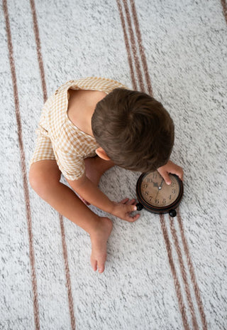 Child playing on Rugabub Cala neutral striped non toxic foam baby play mat.