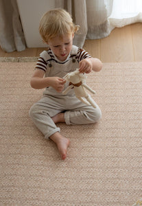 double sided foam padded play mat that looks like a woven knotted rug in neutral colour