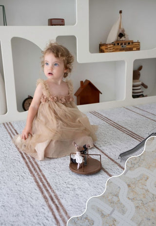 Child playing on Rugabub Cala neutral striped non toxic foam baby play mat in modern nursery.
