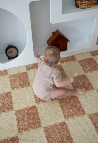 Baby sitting on Rugabub checkered Phoenix non toxic foam baby play mat in a modern nursery in Australia.