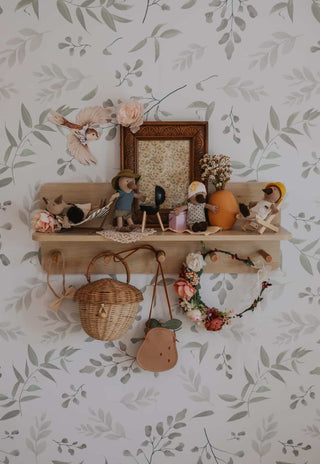 Decorative shelf with various australian platypus miniature dolls against a floral wallpaper background