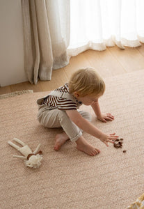 foam padded play mat that looks like a woven knotted rug in neutral colour and is double sided