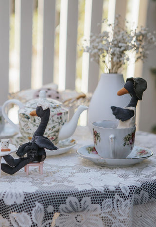 Reed the Wetlands Ranger Rugaroo black swan doll in a vintage tea cup beside Maali the Ballerina - collectible Australian heirloom plush toys for small-world play