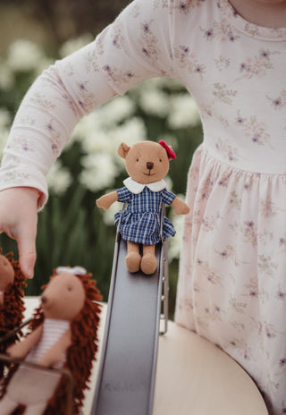 Maisie the Prep Wombat doll from Rugaroo sitting on a miniature toy slide