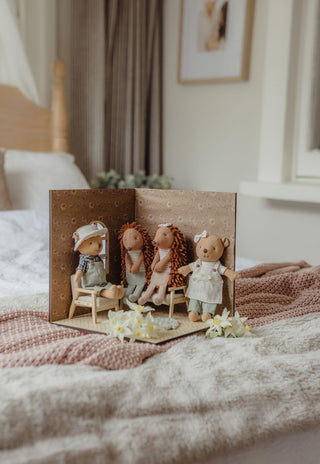 Miniature dollhouse scene with Rugaroo heirloom dolls Wazza the Wombat, Col and Riva the Echidnas, and Marg the Barista Wombat on a bed